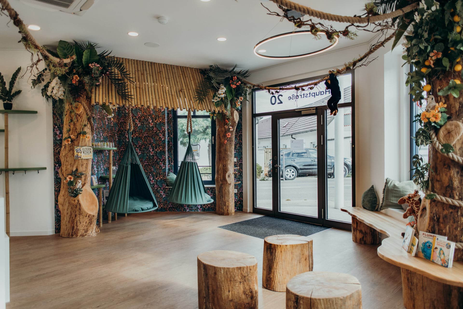 Dschungel-Lounge bei kidsReinisch mit Hängematten, Holzstämmen und Blick zum Eingang